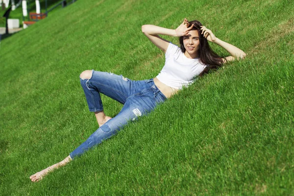 Portret młodej pięknej dziewczyny spoczywającej na trawniku w PA — Zdjęcie stockowe