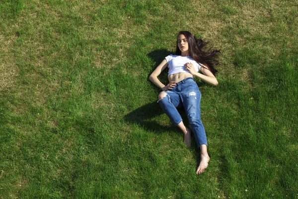 Portrét mladé krásné dívky, která odpočívá na trávníku v PA — Stock fotografie