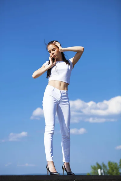 Mooie brunette vrouw poseren tegen Blue Sky Bright Sunny we — Stockfoto