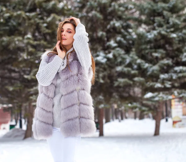 Portrait of a young beautiful brunette girl in fur vest posing i — 스톡 사진