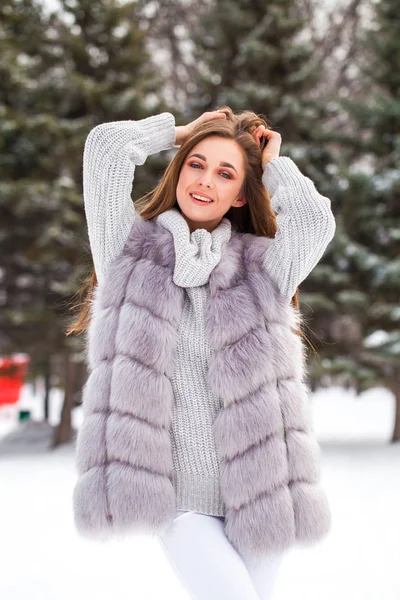 Portret van een jong mooi brunette meisje in bont vest poseren i — Stockfoto