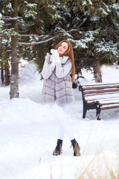 Portrait of a young beautiful brunette girl in fur vest posing i — 스톡 사진