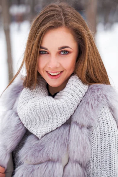 Portrait of a young beautiful brunette girl in fur vest posing i — 스톡 사진