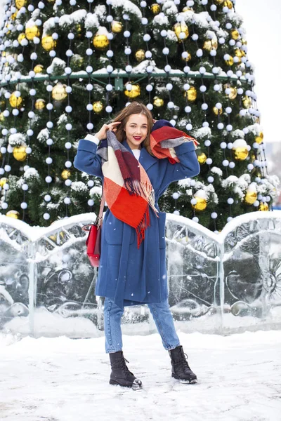 Portrait of young girl in blue jeans walking in a winter park — 스톡 사진