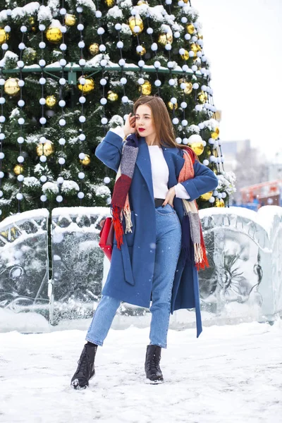 Portrait of young girl in blue jeans walking in a winter park — Stock Photo, Image