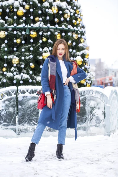 Portrait of young girl in blue jeans walking in a winter park — 스톡 사진