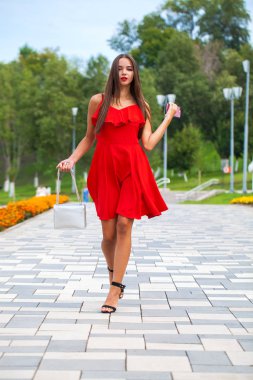 Yaz sokakta yürüyen kırmızı elbiseli genç güzel model