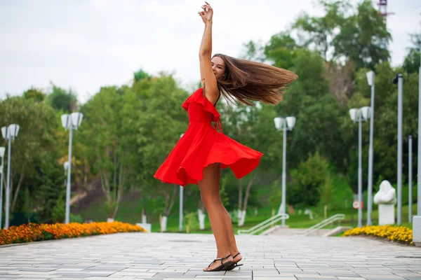 Ung vacker flicka i röd klänning gå på sommar gatan — Stockfoto