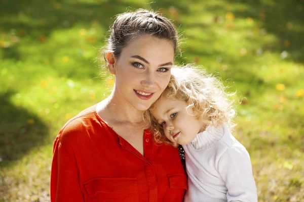 Küçük kıvırcık d ile genç güzel bir annenin Closeup portre — Stok fotoğraf