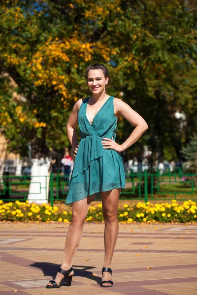 Ung vacker kvinna i mörkblå klänning gå på sommaren s — Stockfoto