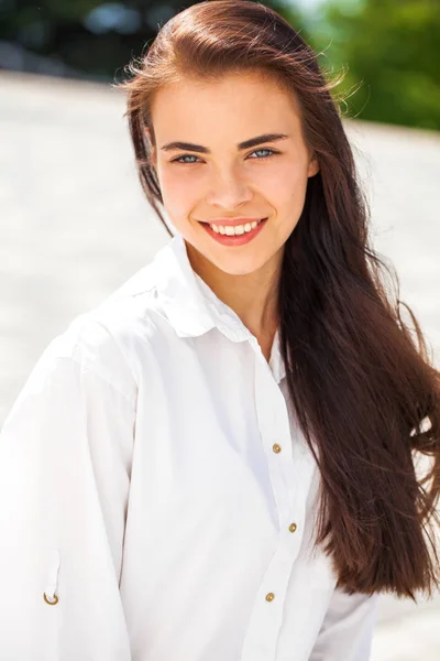 Jovem bela menina morena em camisa branca posando na primavera pa — Fotografia de Stock