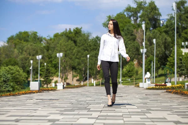 Joven hermosa mujer morena en camisa blanca caminando en verano —  Fotos de Stock