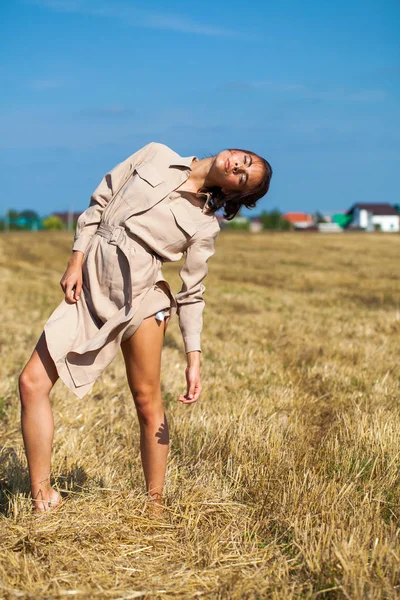 Mladá krásná brunetka v béžových šatech představujících proti t — Stock fotografie