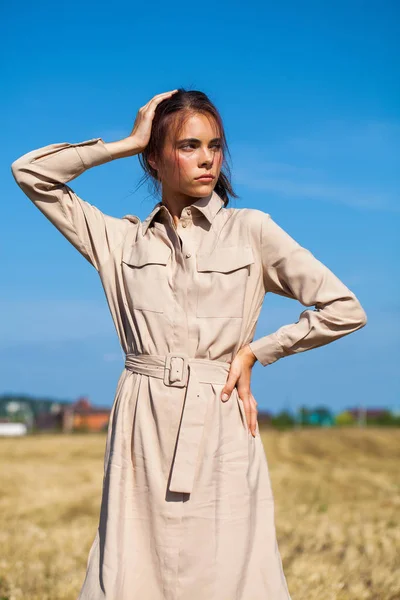 Ung vacker brunett modell i en beige klänning poserar mot — Stockfoto