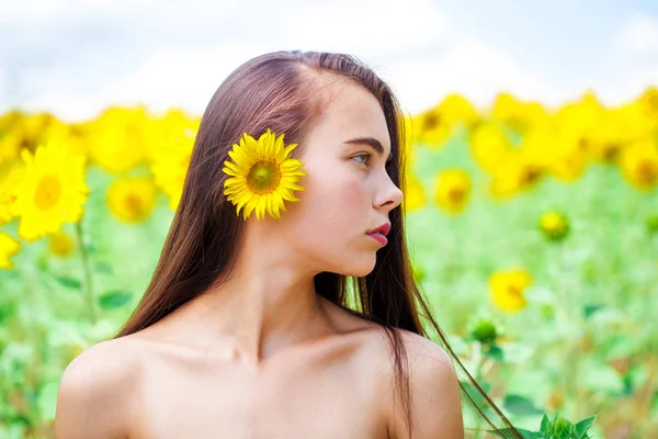 Fotografie krásné brunetky žena v slunečnice pole — Stock fotografie