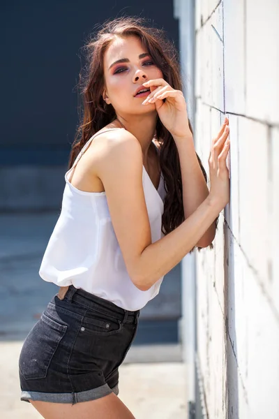 Bonita joven modelo morena en blusa de verano blanca y jeans, su — Foto de Stock