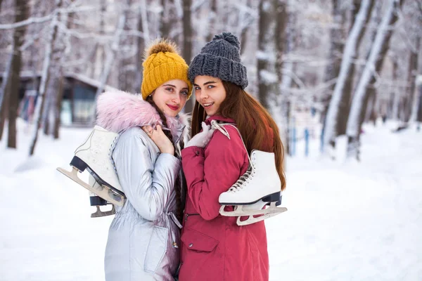 Happy beautiful brunette women with ice skates go to the rink, w — 스톡 사진