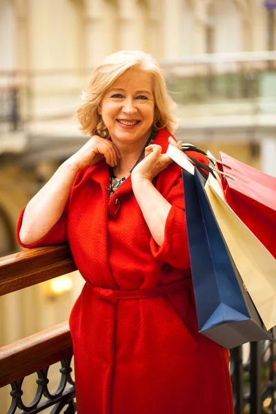 Reife, glückliche Frau mit Einkaufstüten. — Stockfoto