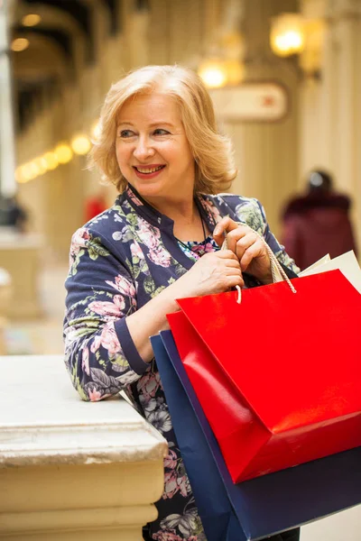 Reife, glückliche Frau mit Einkaufstüten. — Stockfoto