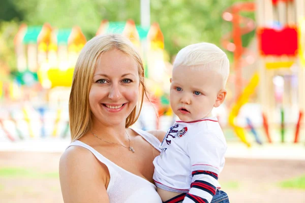 Молодая мать держит на руках его двухлетнего сына — стоковое фото