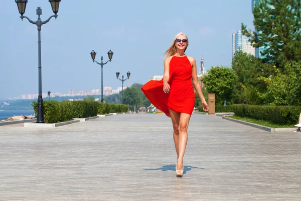 Joven hermosa mujer en vestido rojo caminando en la calle de verano — Foto de Stock