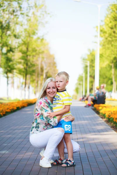 Jonge moeder en zoon spelen in zomer park — Stockfoto