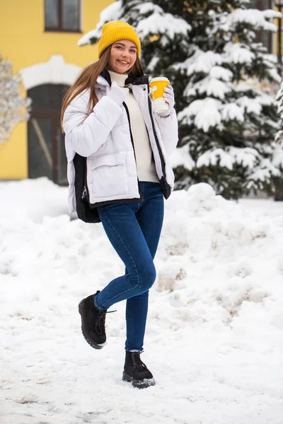 Full-length portrait of a young cheerful woman in a white down j — Stock Photo, Image