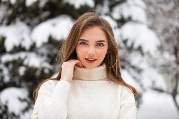 Junge schöne Frau in einem Wollpullover posiert auf einem Hintergrund — Stockfoto