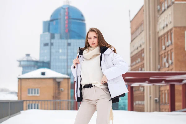 Fshion dziewczyna w białym dół kurtka i beżowe spodnie pozowanie outdoo — Zdjęcie stockowe