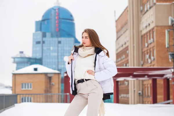 Fshion ragazza in un piumino bianco e pantaloni beige in posa outdoo — Foto Stock