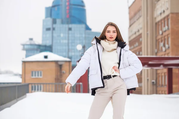 Fshion ragazza in un piumino bianco e pantaloni beige in posa outdoo — Foto Stock