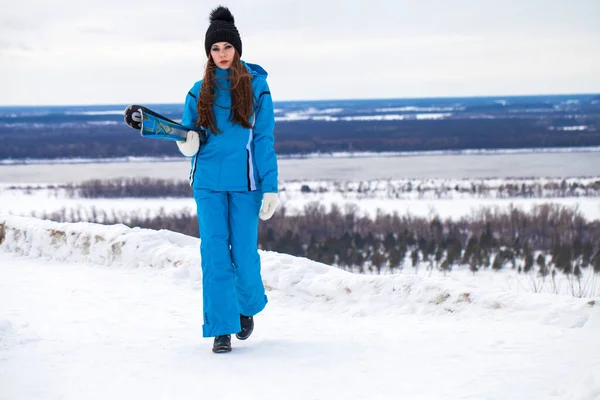 Jeune femme brune en costume de ski posant sur une colline — Photo