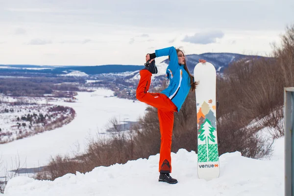 Молодая брюнетка в лыжном костюме позирует на вершине холма — стоковое фото
