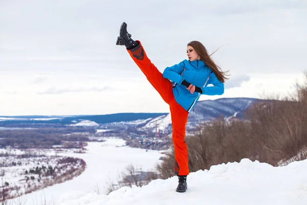 穿着滑雪服的年轻黑发女子在山顶上摆姿势 — 图库照片