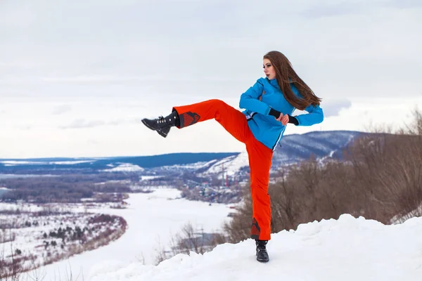 Giovane donna bruna in tuta da sci in posa su una collina — Foto Stock