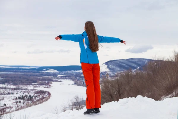 Jong brunette vrouw in een ski pak poseren op een heuveltop — Stockfoto