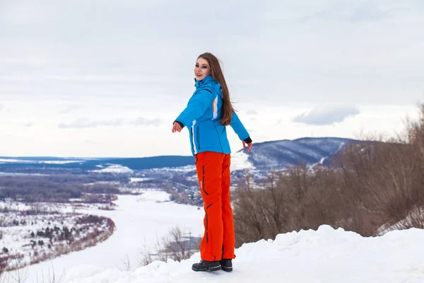 Giovane donna bruna in tuta da sci in posa su una collina — Foto Stock