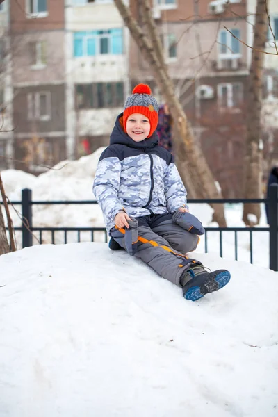 Ritratto di un bambino con un cappello rosso a maglia nel parco invernale — Foto Stock