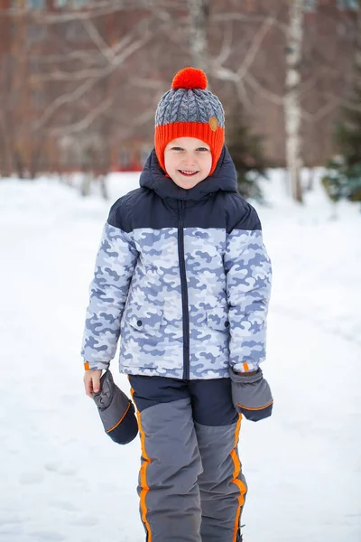 Portret van een jongetje met een rode gebreide muts in het winterpark — Stockfoto