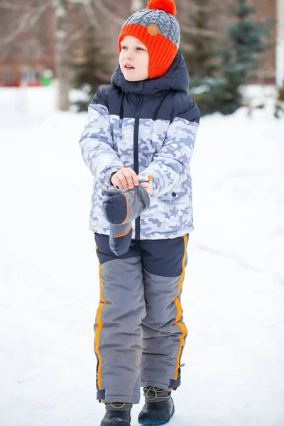Portrait of a little boy in a red knitted hat in winter park — Stock Photo, Image