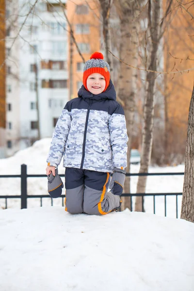 Portret van een jongetje met een rode gebreide muts in het winterpark — Stockfoto