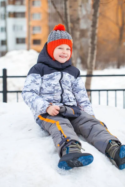 Portret van een jongetje met een rode gebreide muts in het winterpark — Stockfoto