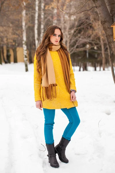 Νεαρή όμορφη γυναίκα σε κίτρινο παλτό περπάτημα χειμερινό πάρκο — Φωτογραφία Αρχείου