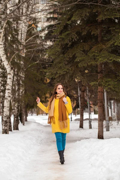 Giovane bella donna in cappotto giallo a piedi parco invernale — Foto Stock