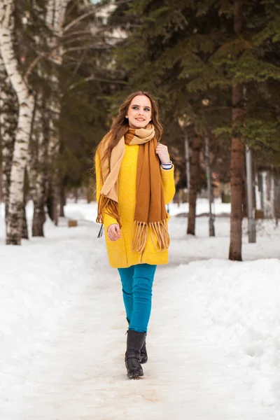 Молода красива жінка в жовтому пальто йде зимовий парк — стокове фото