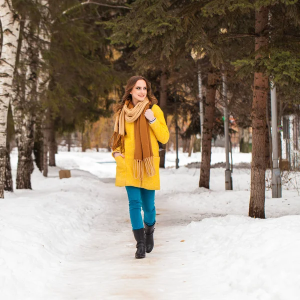 Giovane bella donna in cappotto giallo a piedi parco invernale — Foto Stock