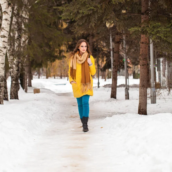 Joven hermosa mujer en abrigo amarillo caminando parque de invierno — Foto de Stock