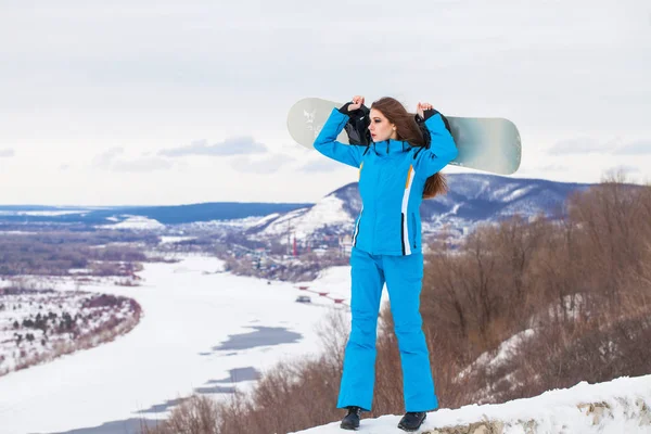 Portret młodej pięknej brunetki z snowboardem — Zdjęcie stockowe