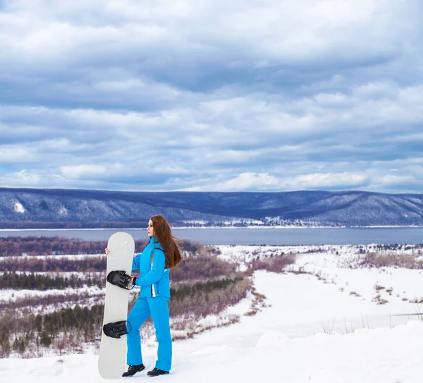 スノーボードを持つ若い美しいブルネットの女性の肖像 — ストック写真
