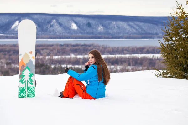 Portret młodej pięknej brunetki z snowboardem — Zdjęcie stockowe